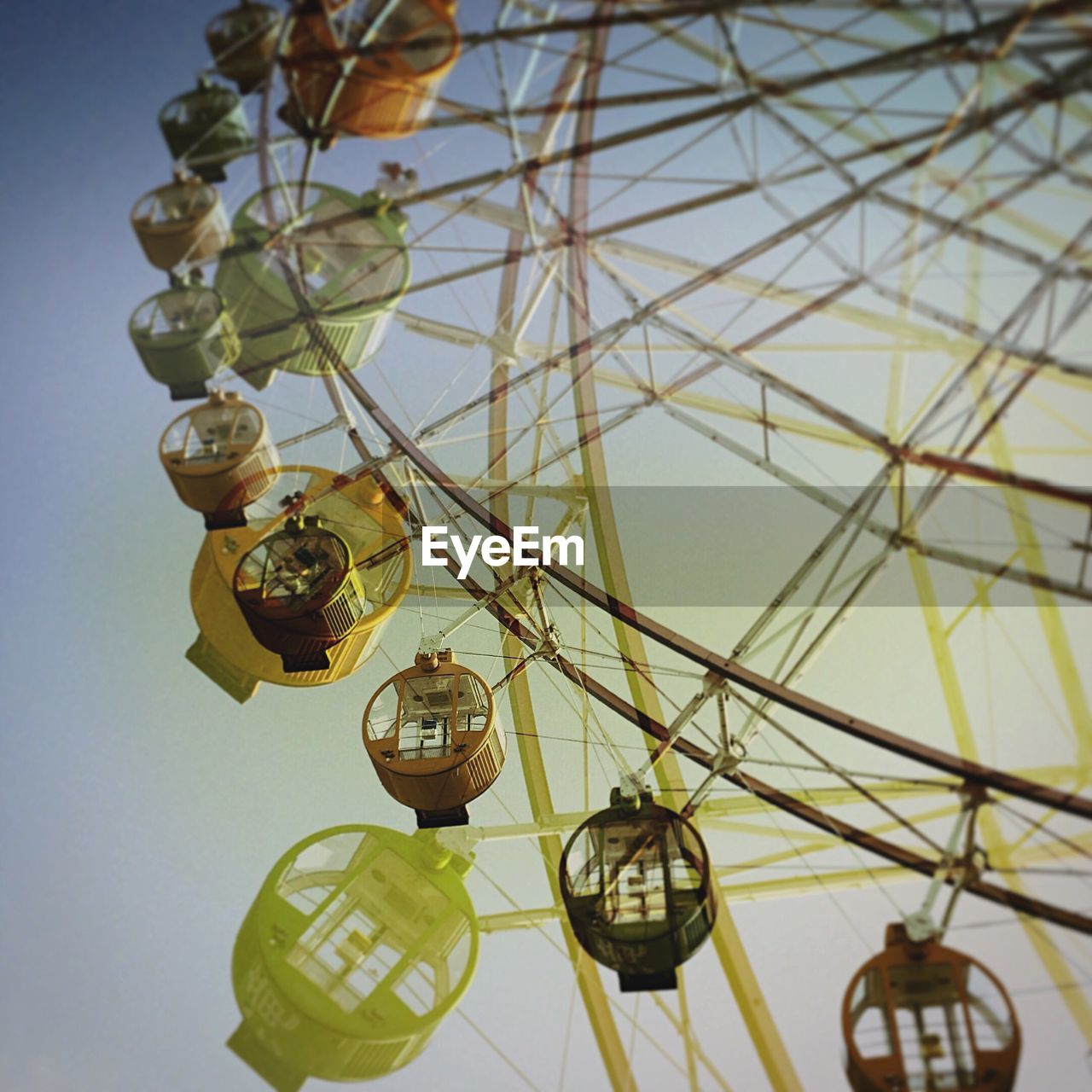 Low angle view of ferris wheels against sky