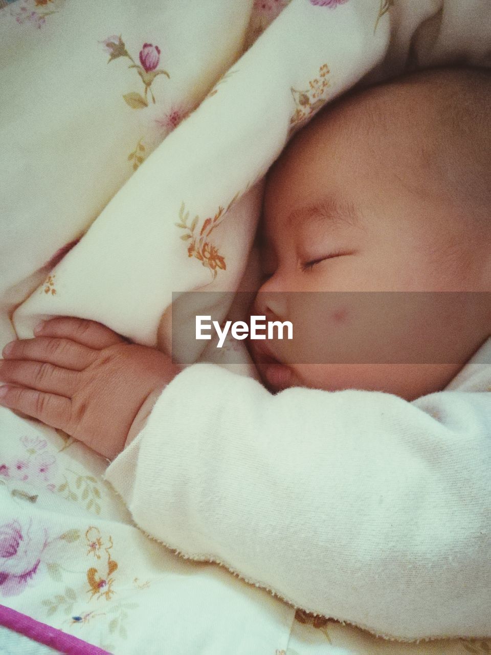 Close-up of baby sleeping on bed