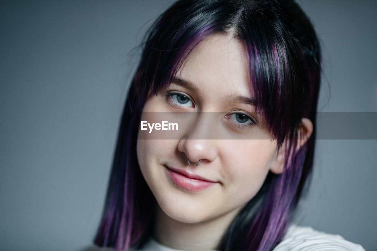 Portrait of a smiling young girl with purple hair close-up