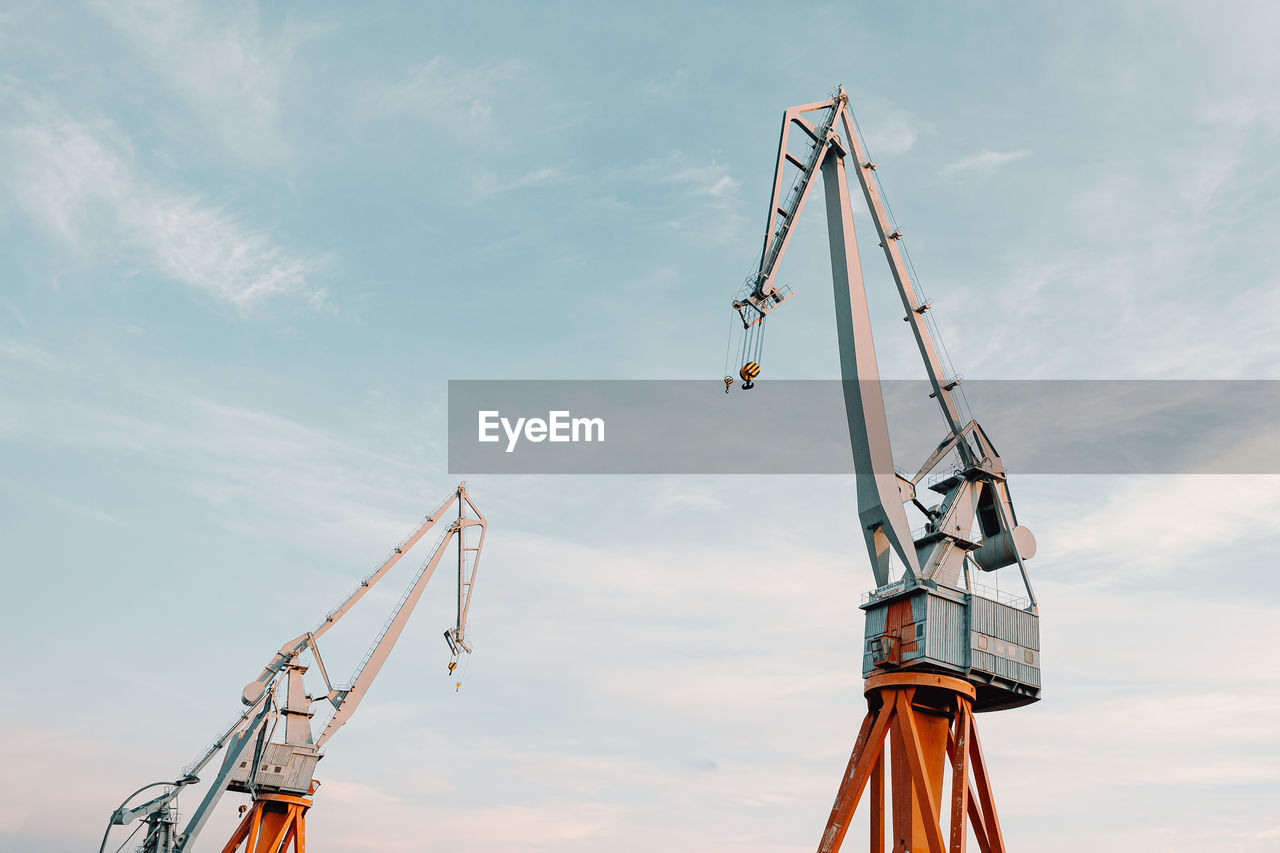 Low angle view of crane against sky