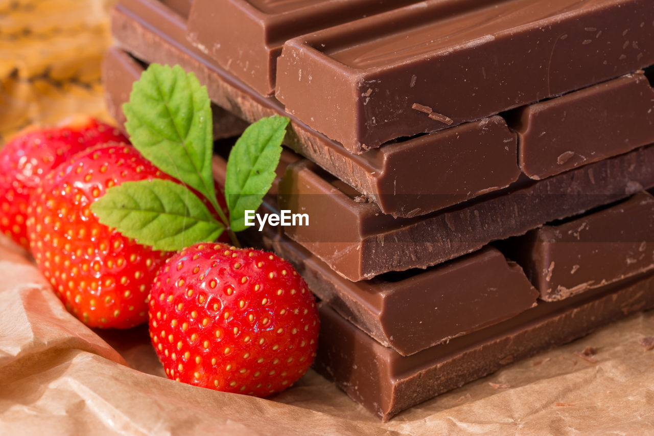 Close-up of strawberries by chocolate bars on table