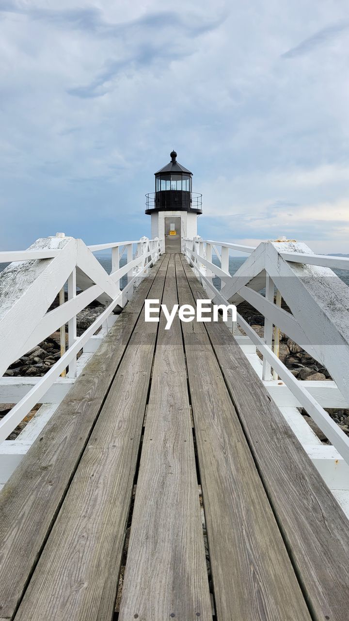 Lighthouse by sea against sky