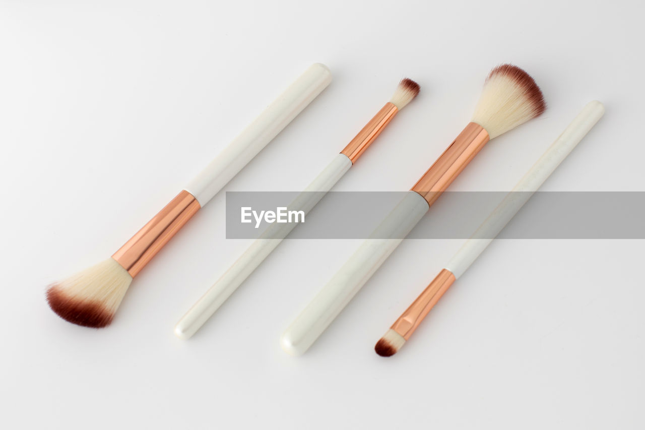 high angle view of make-up brushes on white background