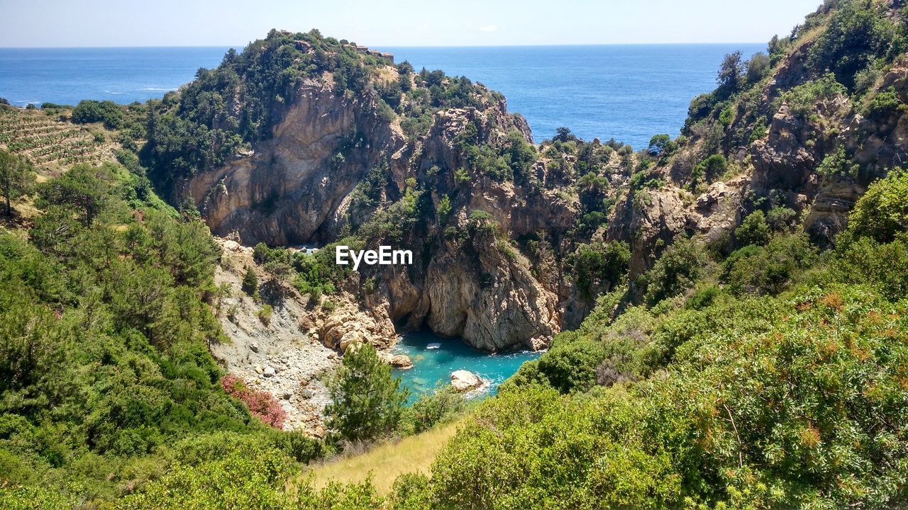 Scenic view of sea and mountains against clear sky