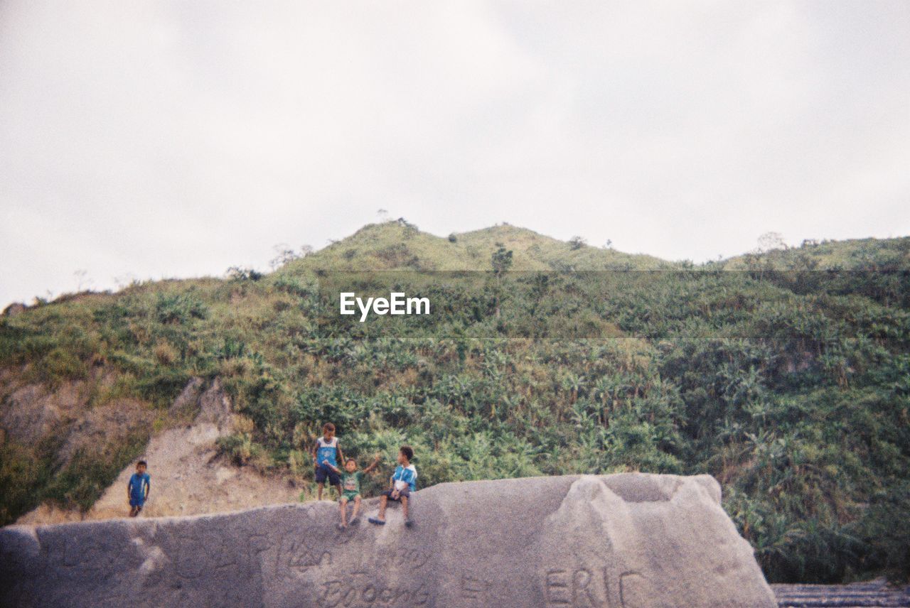 GROUP OF PEOPLE ON MOUNTAIN ROAD