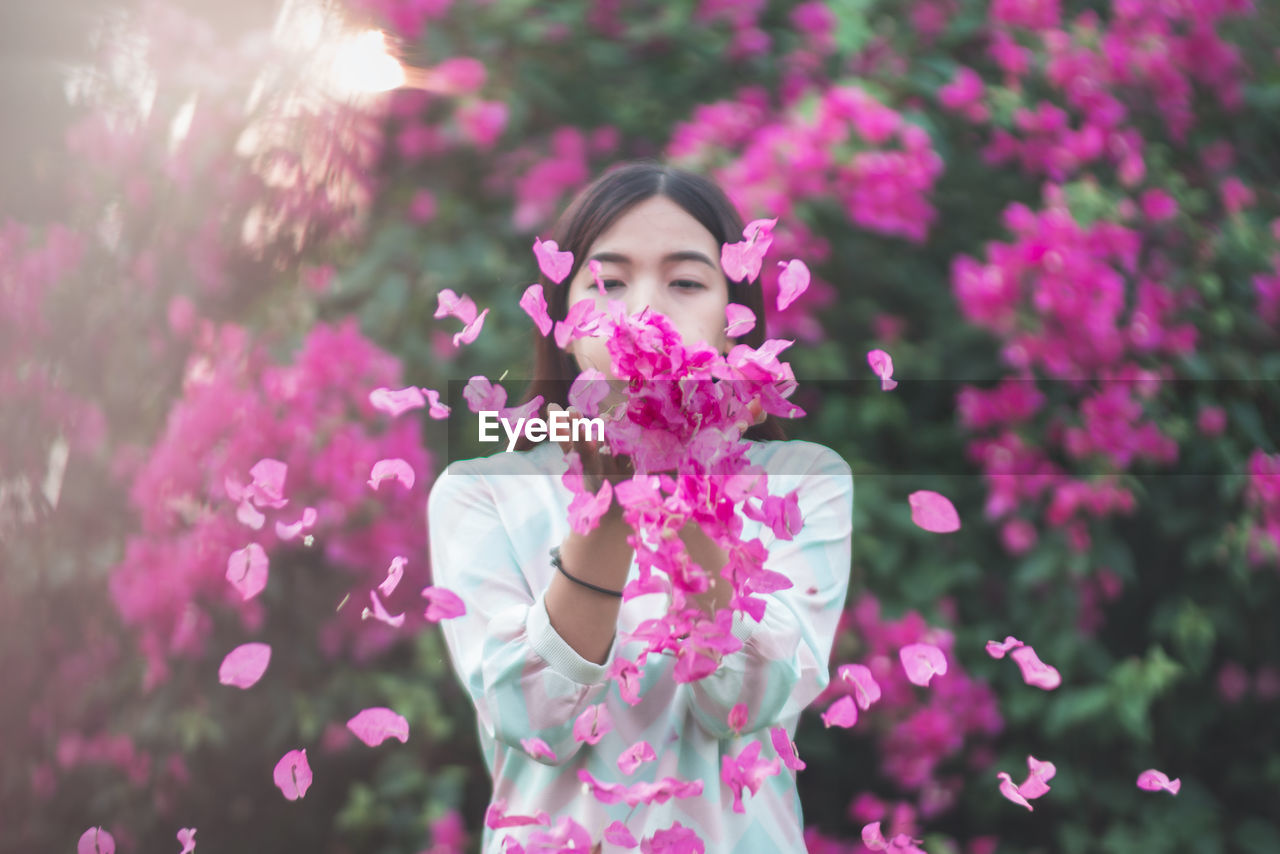 Woman throwing bougainvillea flowers