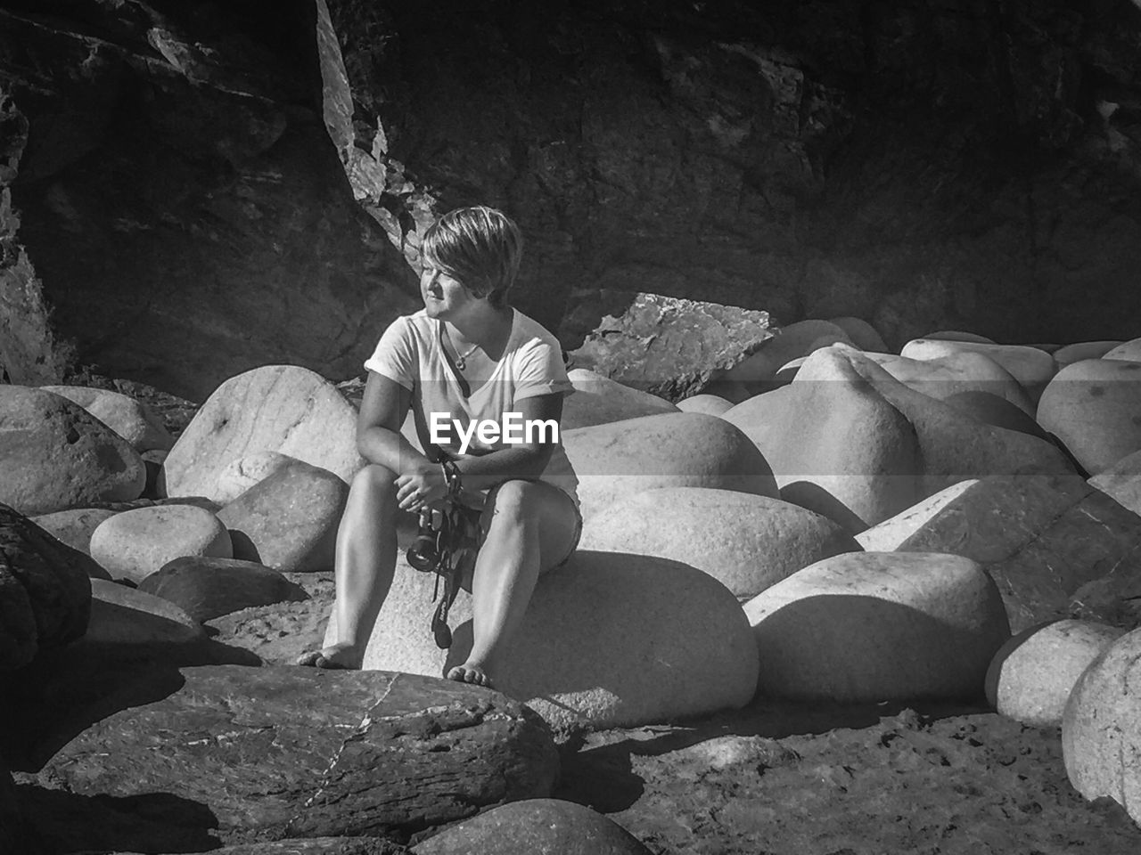 FULL LENGTH OF WOMAN SITTING ON ROCK