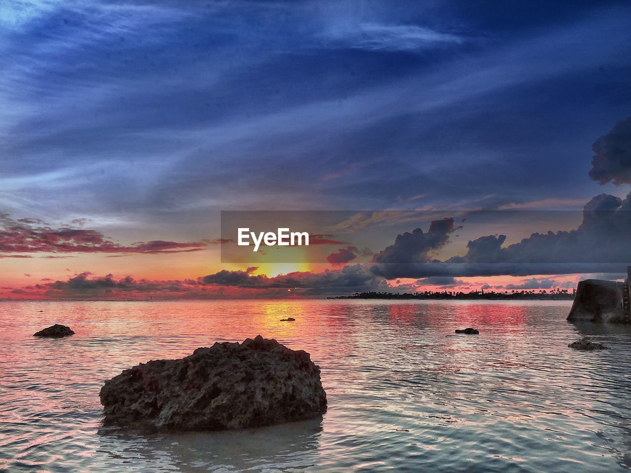 ROCKS BY SEA AGAINST SKY DURING SUNSET