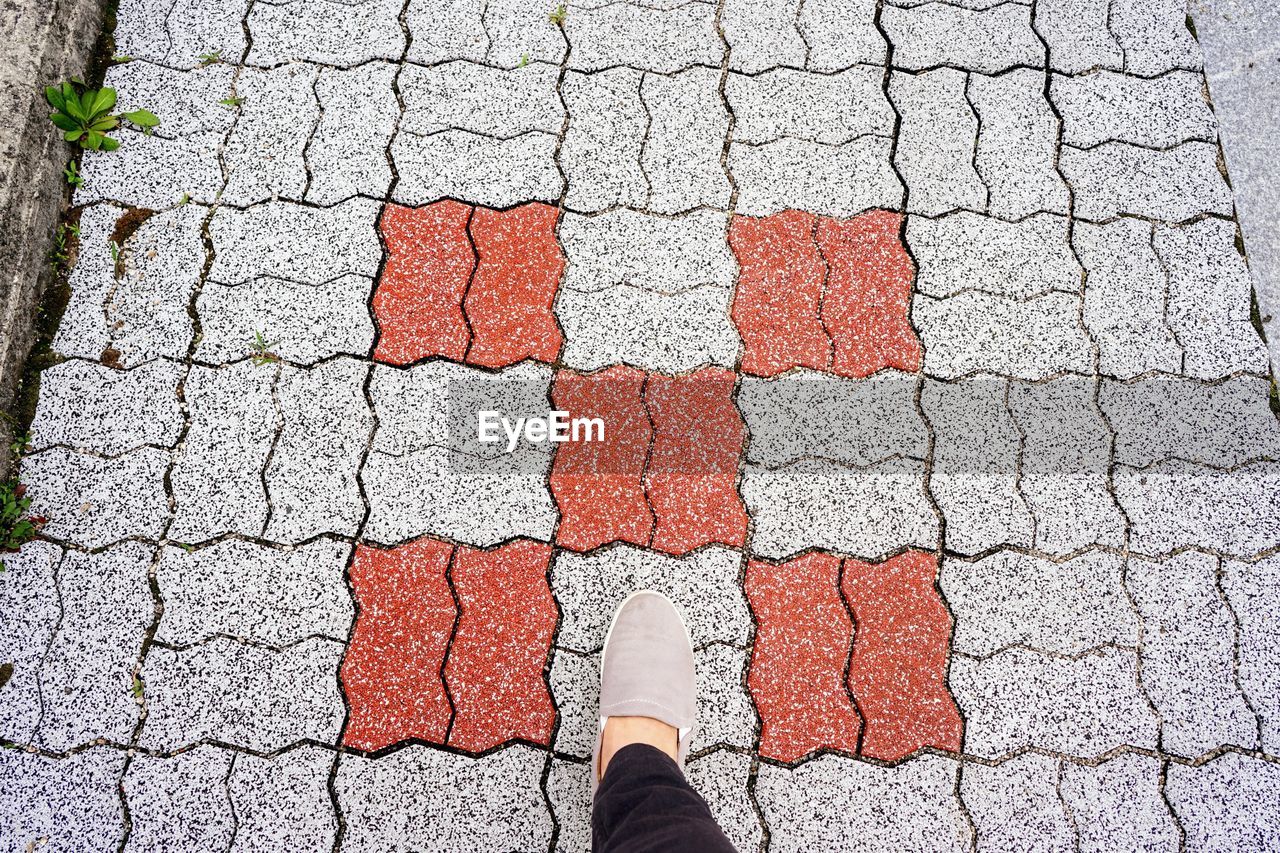 Low section of person standing on footpath