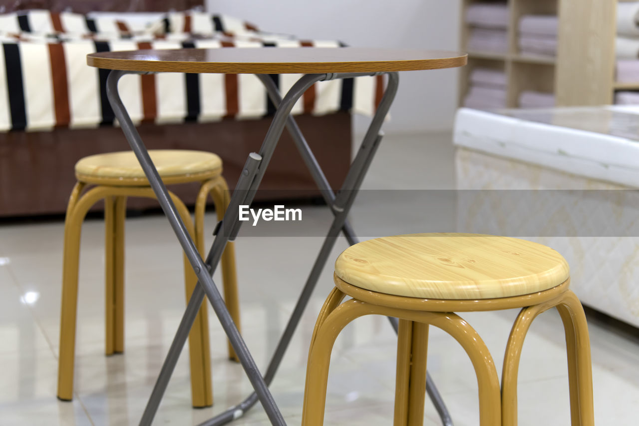 Close-up of empty stools and wooden table