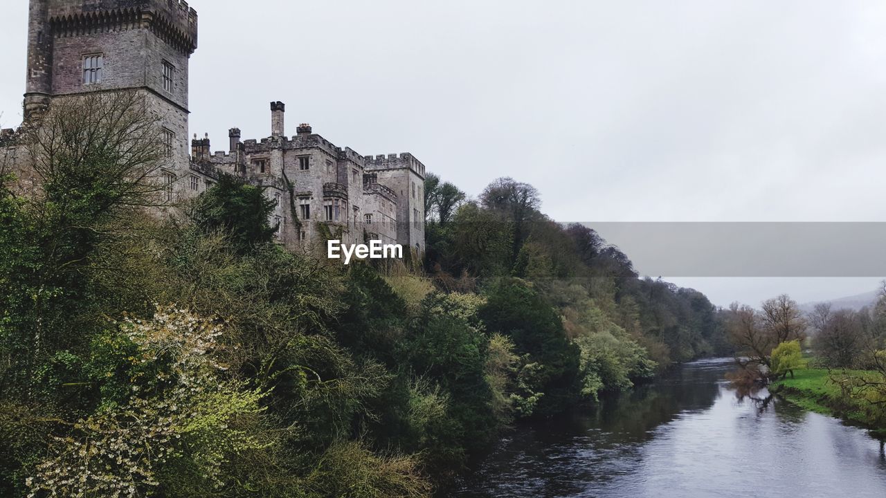 CASTLE BY TREES AGAINST CLEAR SKY