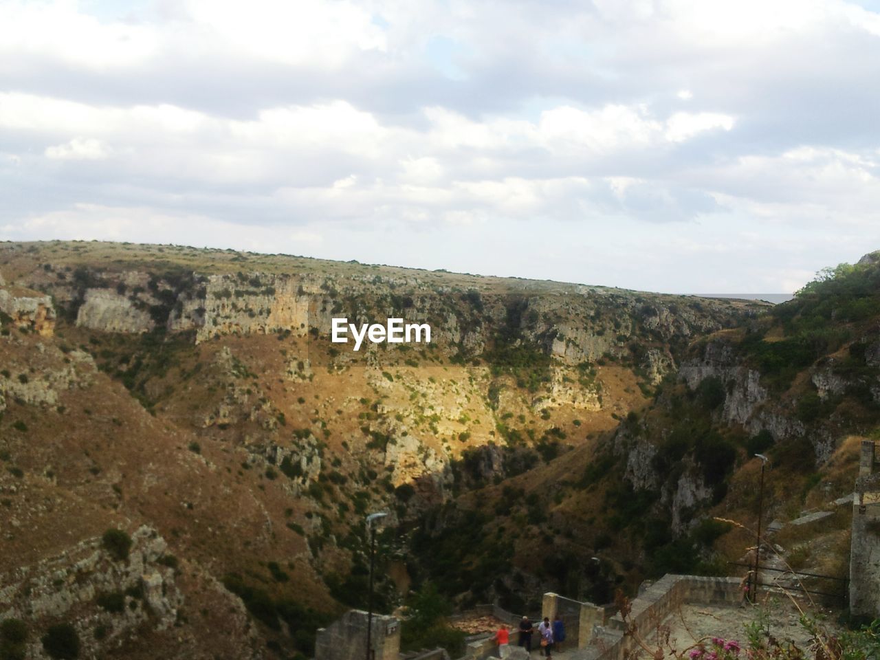 SCENIC VIEW OF MOUNTAINS AGAINST CLOUDY SKY