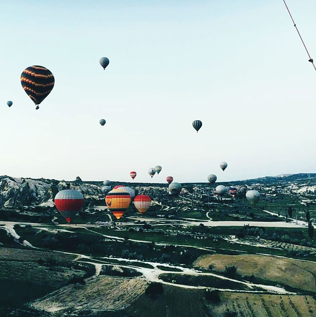 HOT AIR BALLOONS FLYING OVER LANDSCAPE