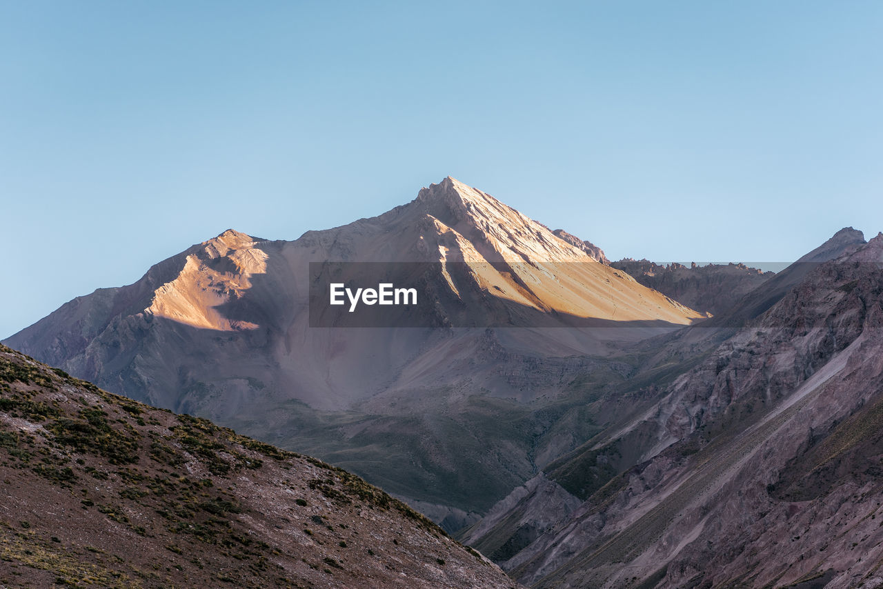 Panoramic view of mountains against clear blue sky