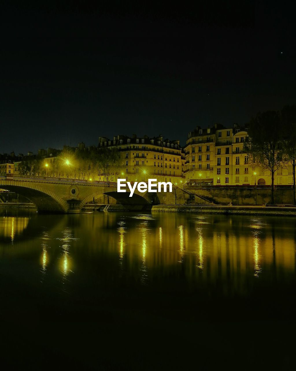 Illuminated bridge over river against sky at night