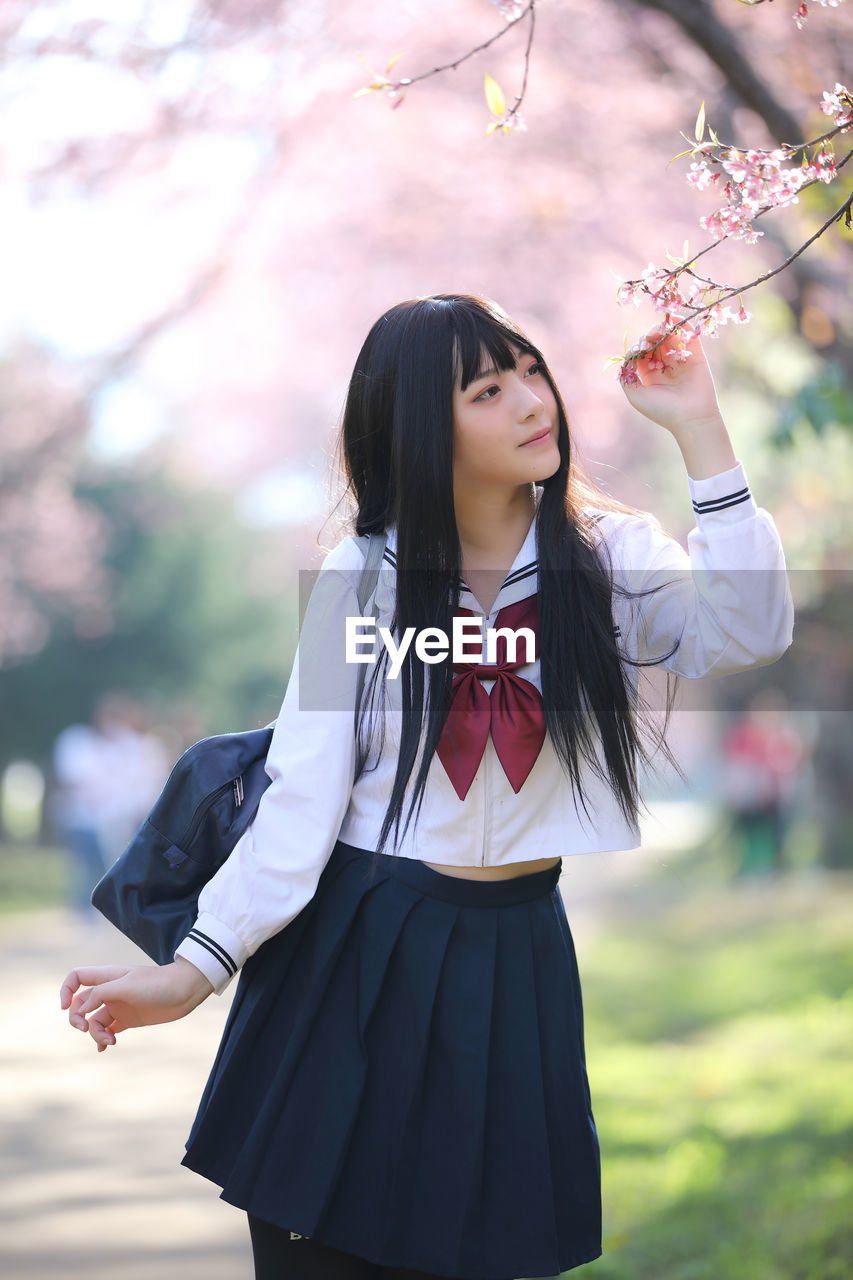 Low section of woman standing on cherry blossom