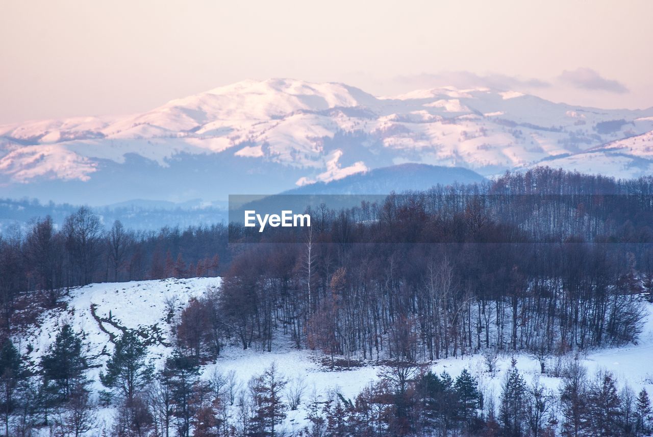 SNOW COVERED MOUNTAINS AGAINST SKY