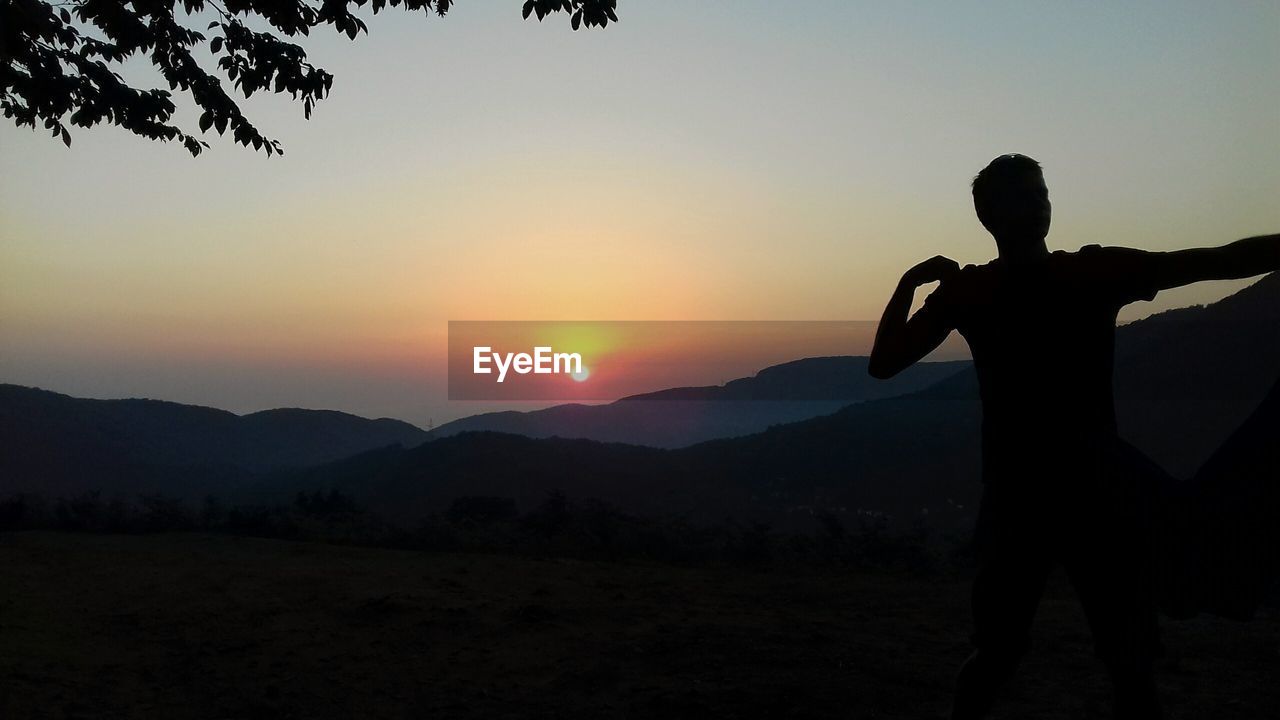 SILHOUETTE MAN STANDING AGAINST SKY DURING SUNSET