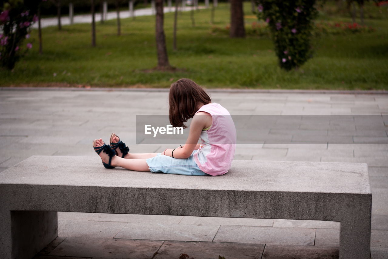 Little girl sitting alone on the bench