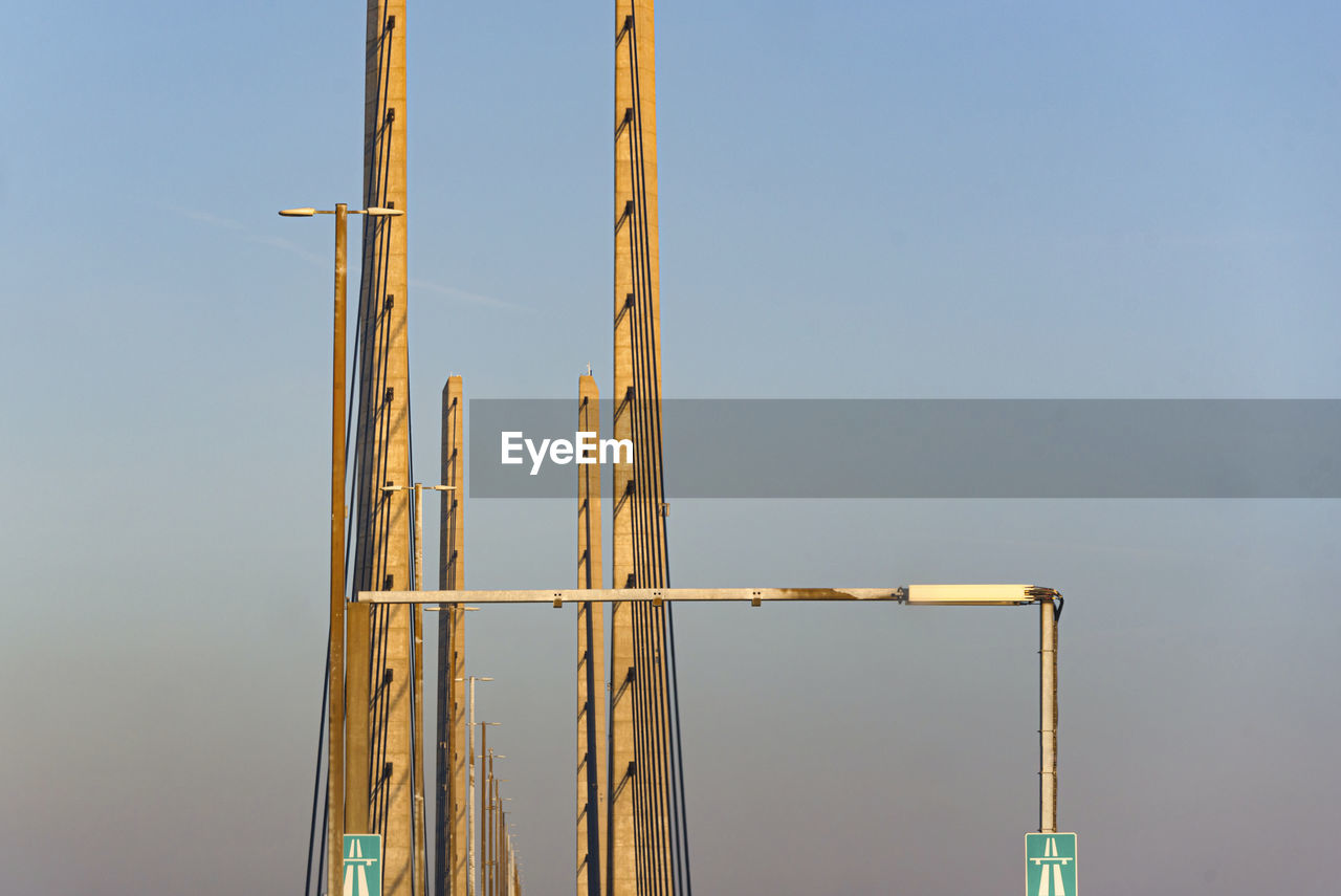 mast, sky, no people, architecture, nature, construction site, industry, construction industry, day, built structure, outdoors, tower, clear sky, overhead power line, crane - construction machinery, blue, electricity, copy space, development, low angle view, line