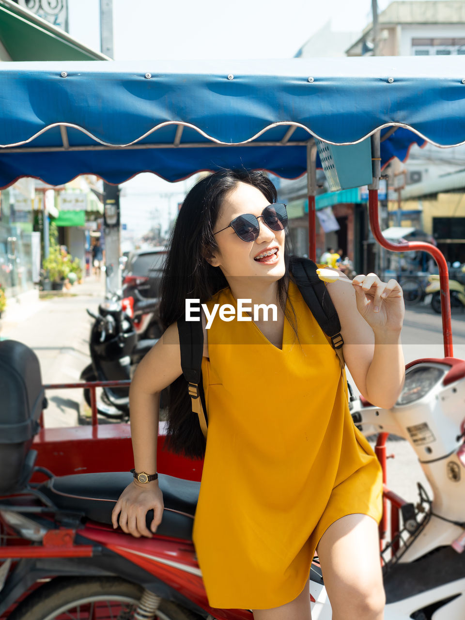 Young woman standing by motorcycle in city