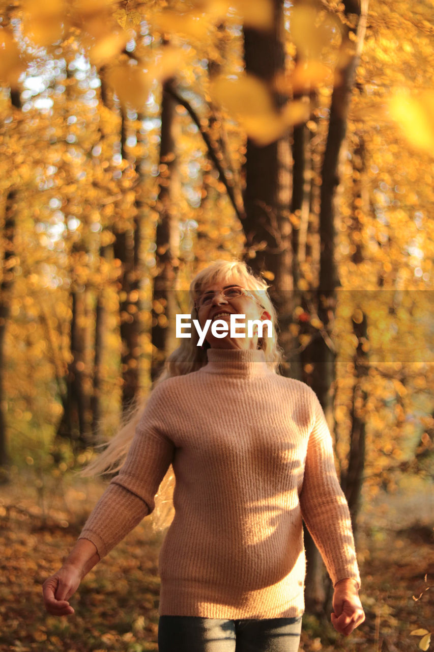 WOMAN STANDING IN FOREST DURING AUTUMN