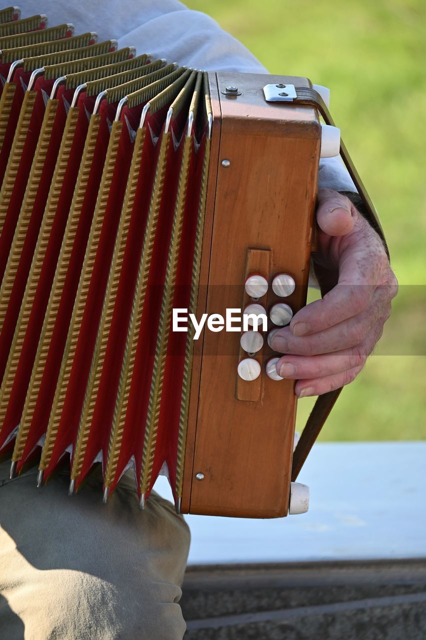 Close-up of hand holding accordion  