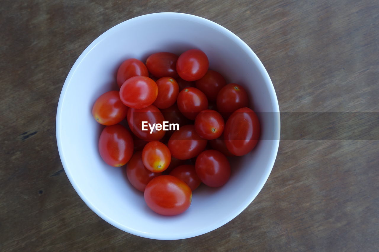 HIGH ANGLE VIEW OF CHERRY TOMATOES IN BOWL ON TABLE