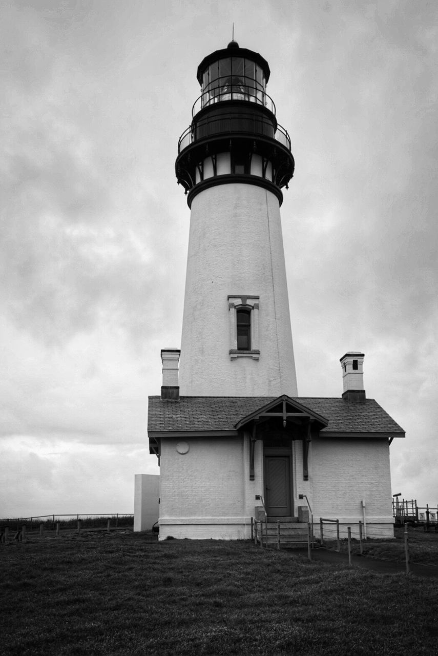 Low angle view of lighthouse on field against sky