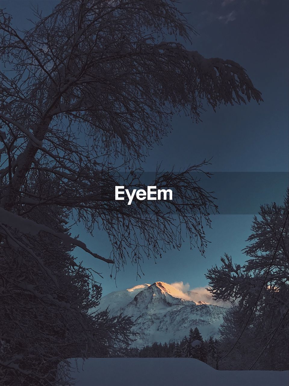 LOW ANGLE VIEW OF SNOWCAPPED MOUNTAIN AGAINST SKY DURING WINTER