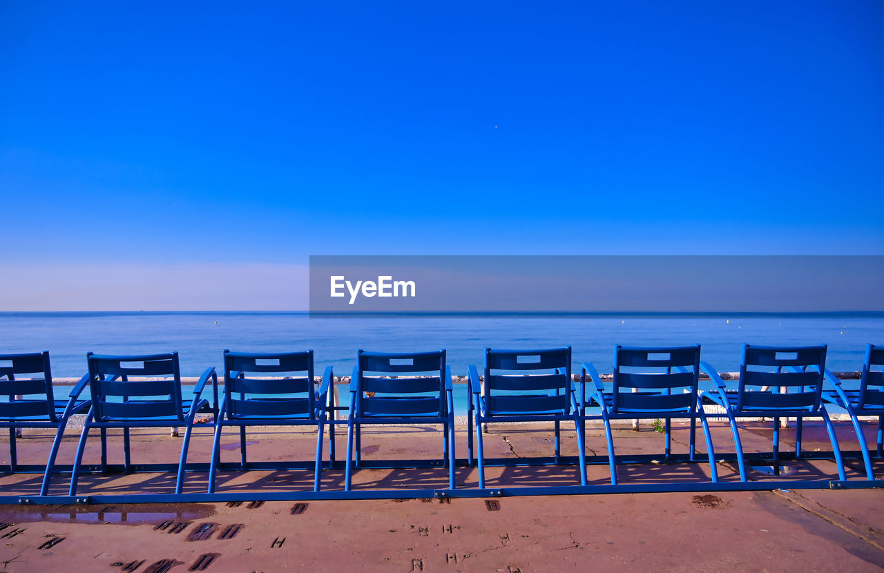 CHAIRS ON BEACH AGAINST BLUE SKY