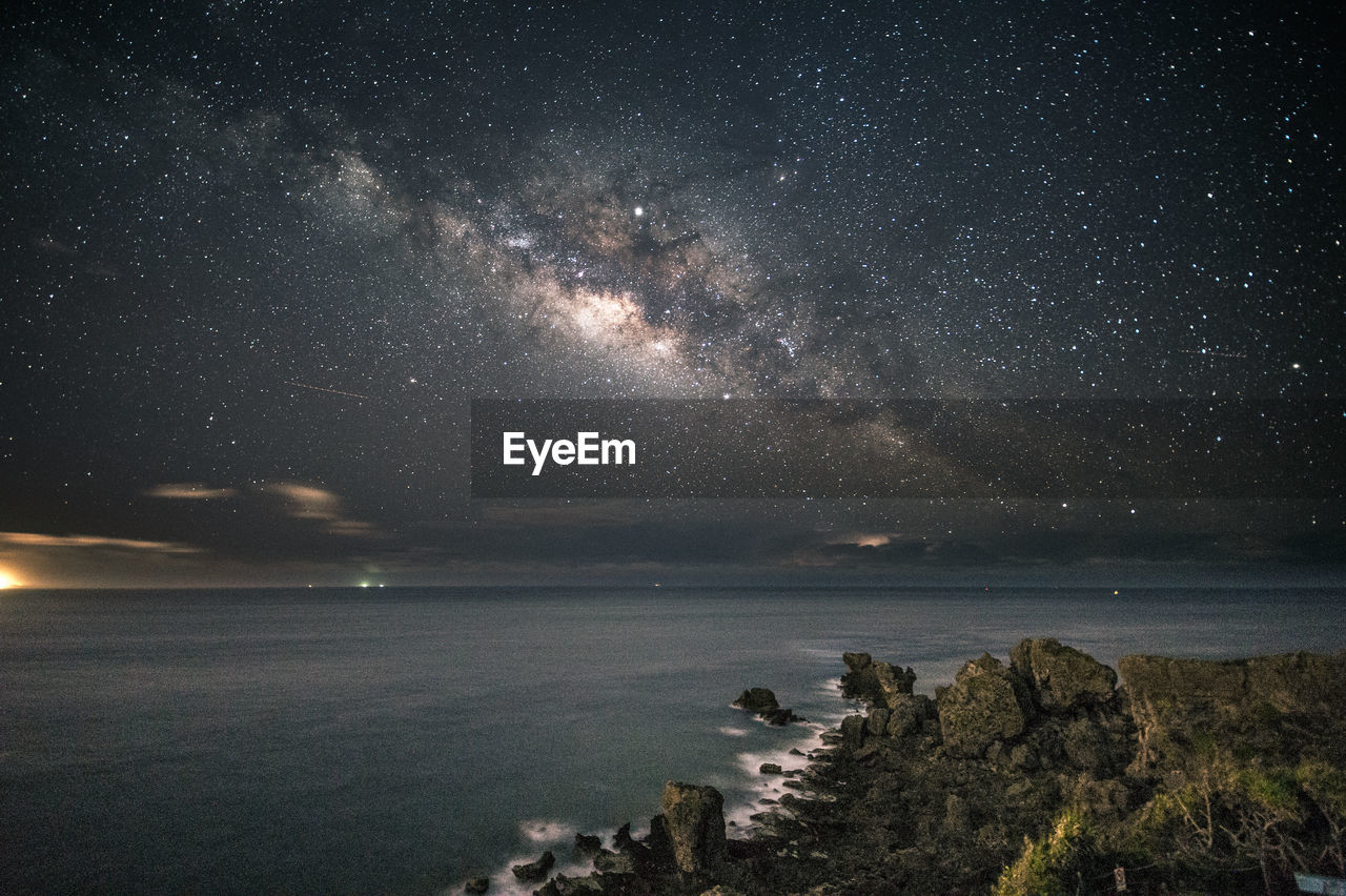 SCENIC VIEW OF SEA AGAINST STAR FIELD