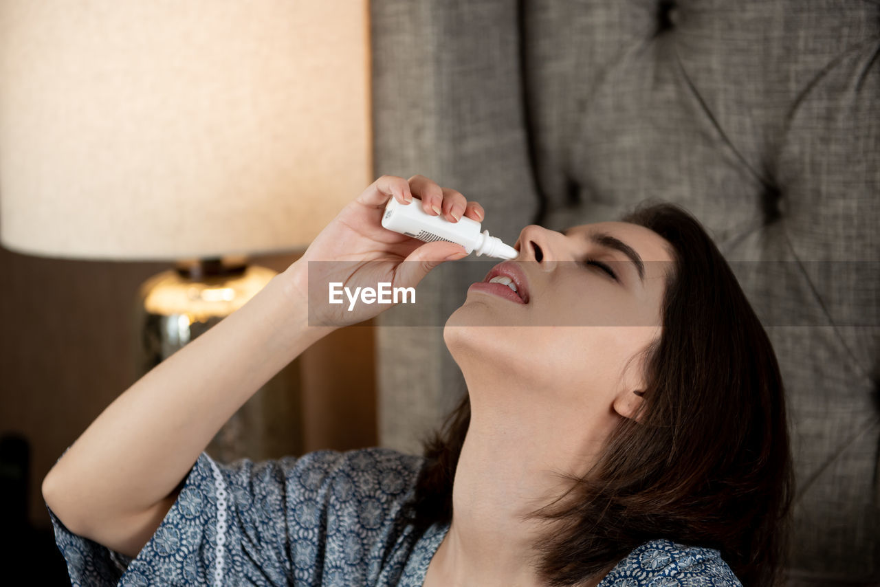 Woman putting drops in nose
