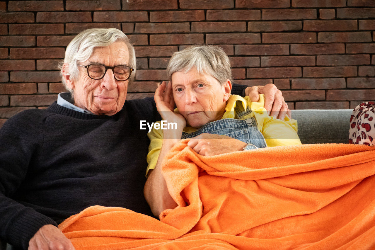 portrait of smiling senior couple sitting on bed