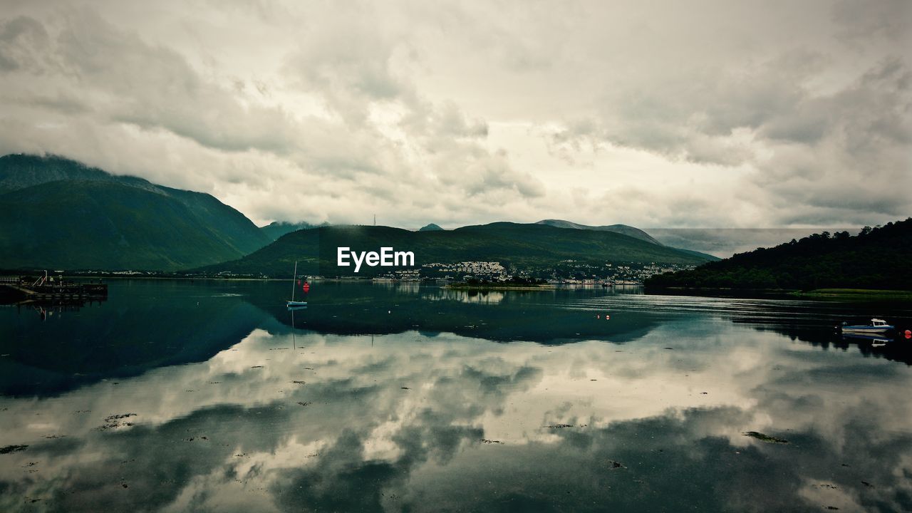 Reflection of cloudy sky on calm lake