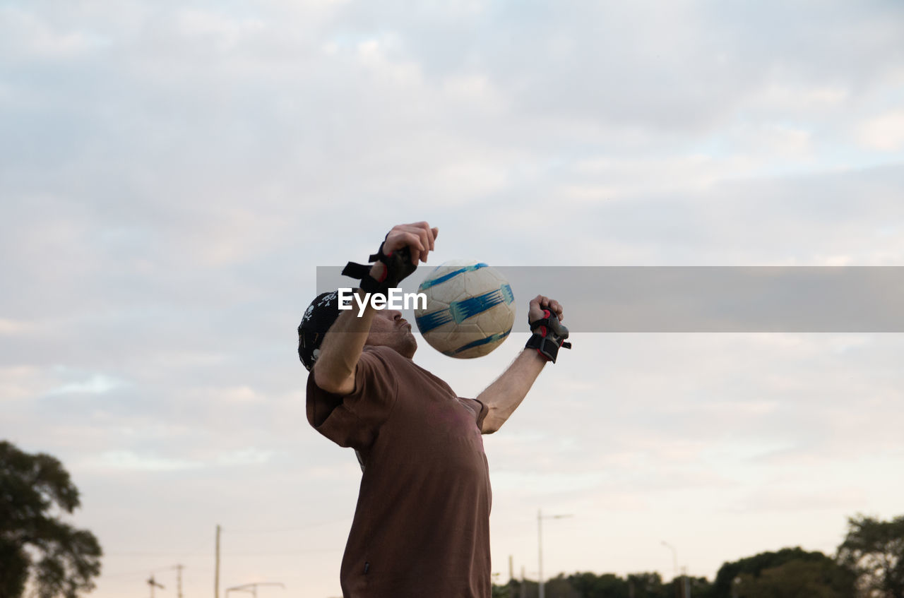 Low angle view of man playing soccer outdoors