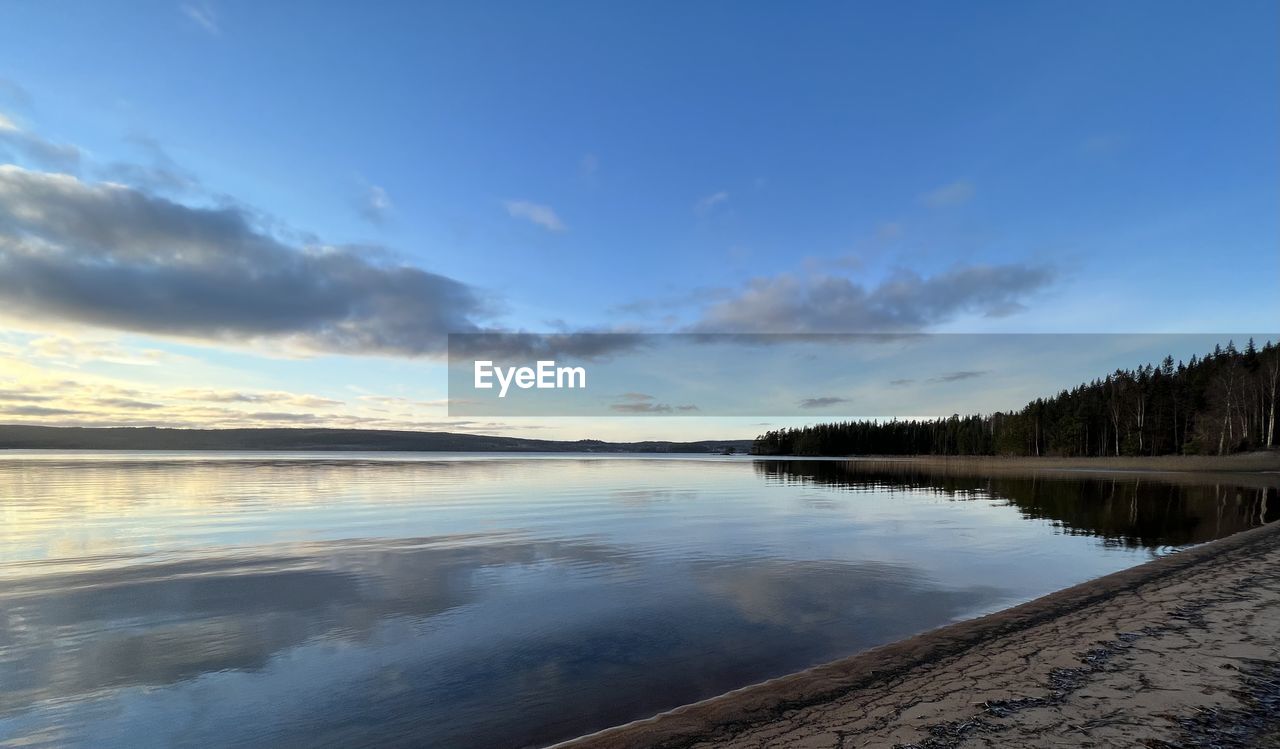 water, sky, reflection, body of water, scenics - nature, shore, cloud, morning, beauty in nature, sea, nature, tranquility, environment, dawn, tranquil scene, landscape, land, beach, horizon, no people, reservoir, tree, wave, blue, sunrise, coast, sunlight, travel destinations, outdoors, non-urban scene, winter, travel, plant, ocean, day, idyllic, snow, mountain, tourism