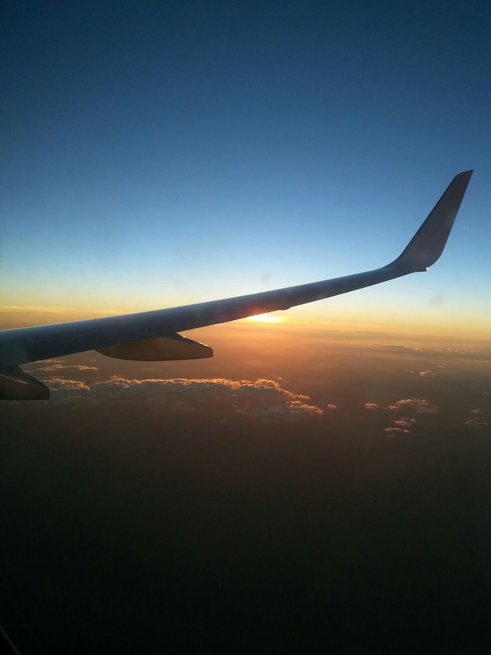 Cropped image of airplane flying during sunset