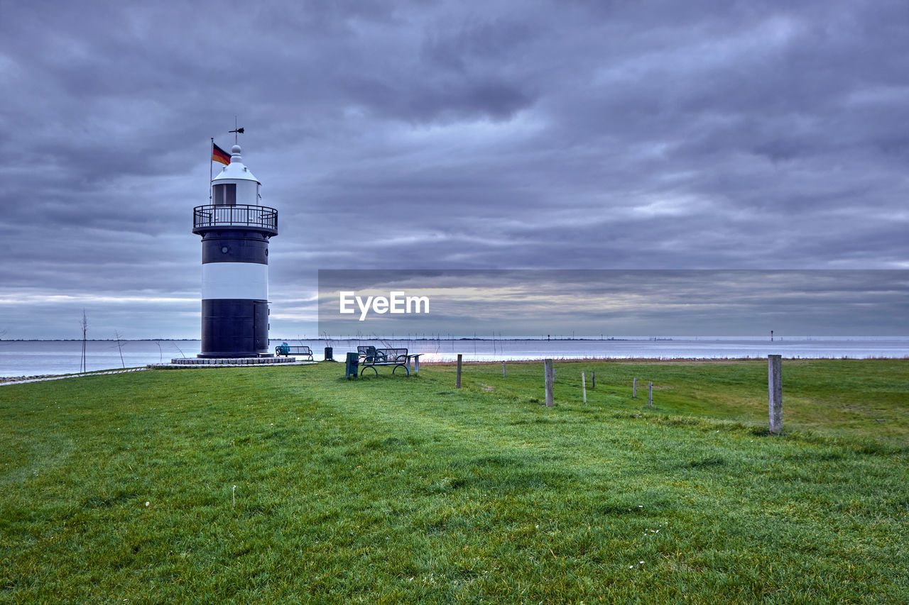 Lighthouse by sea against sky