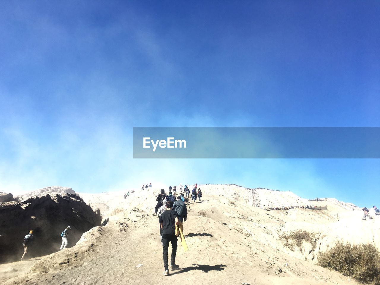 REAR VIEW OF PEOPLE WALKING ON LAND