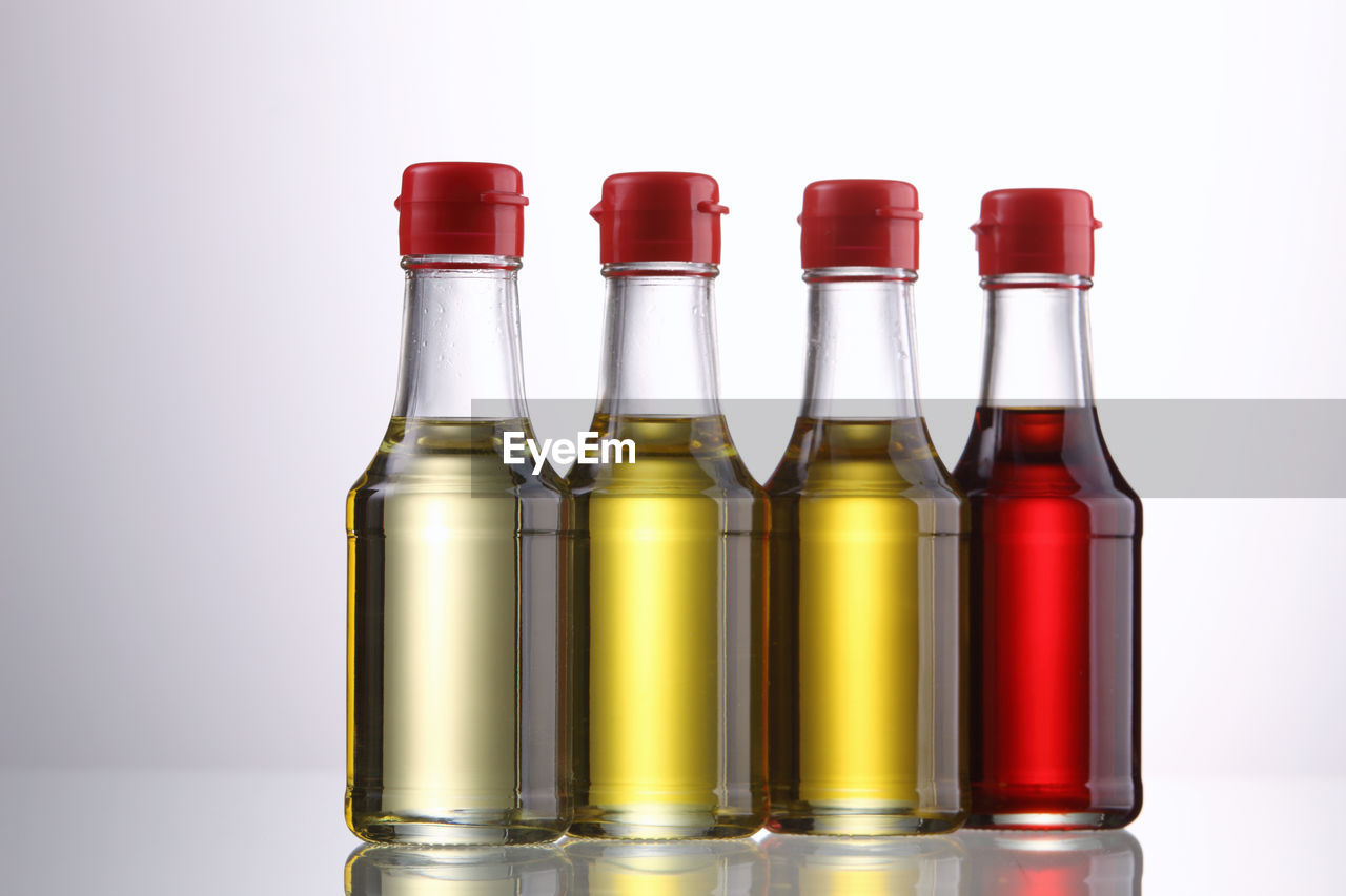 Close-up of cooking oil in bottles against white background