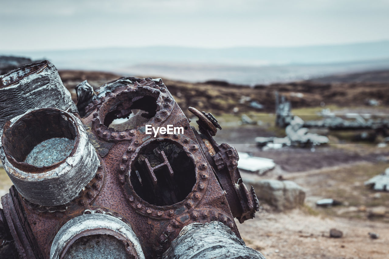 Close-up of rusty machine part on field