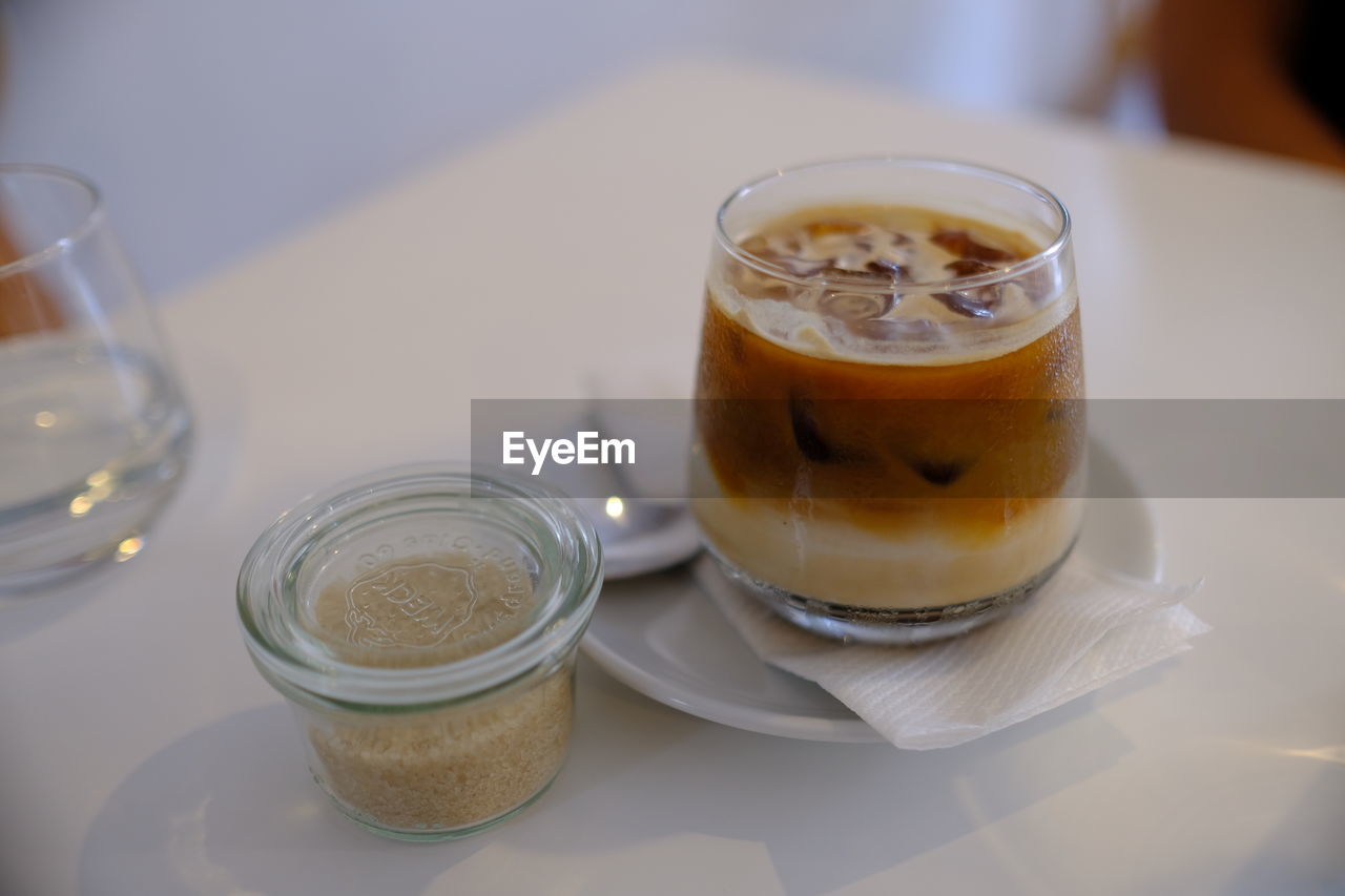 CLOSE-UP OF COFFEE AND JUICE ON TABLE