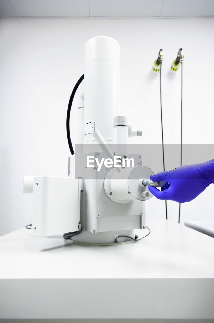 Cropped image of scientist using machinery in laboratory