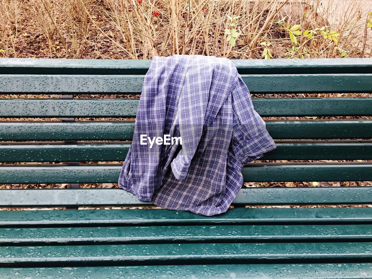 Close-up of plaid shirt over a bench 