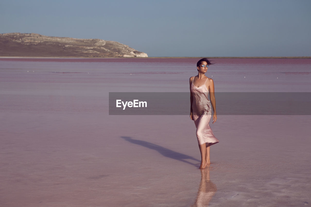 Woman on a dried up salt lake in a pink dress in the crimea