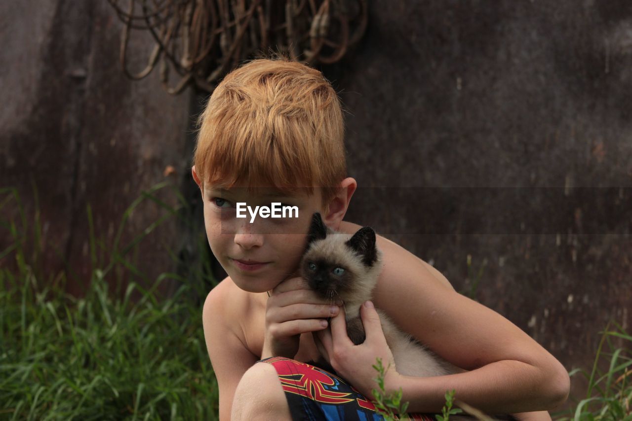 Cute boy holding cat