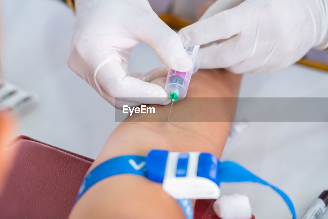 Nurse collecting a blood from patient in hospital.