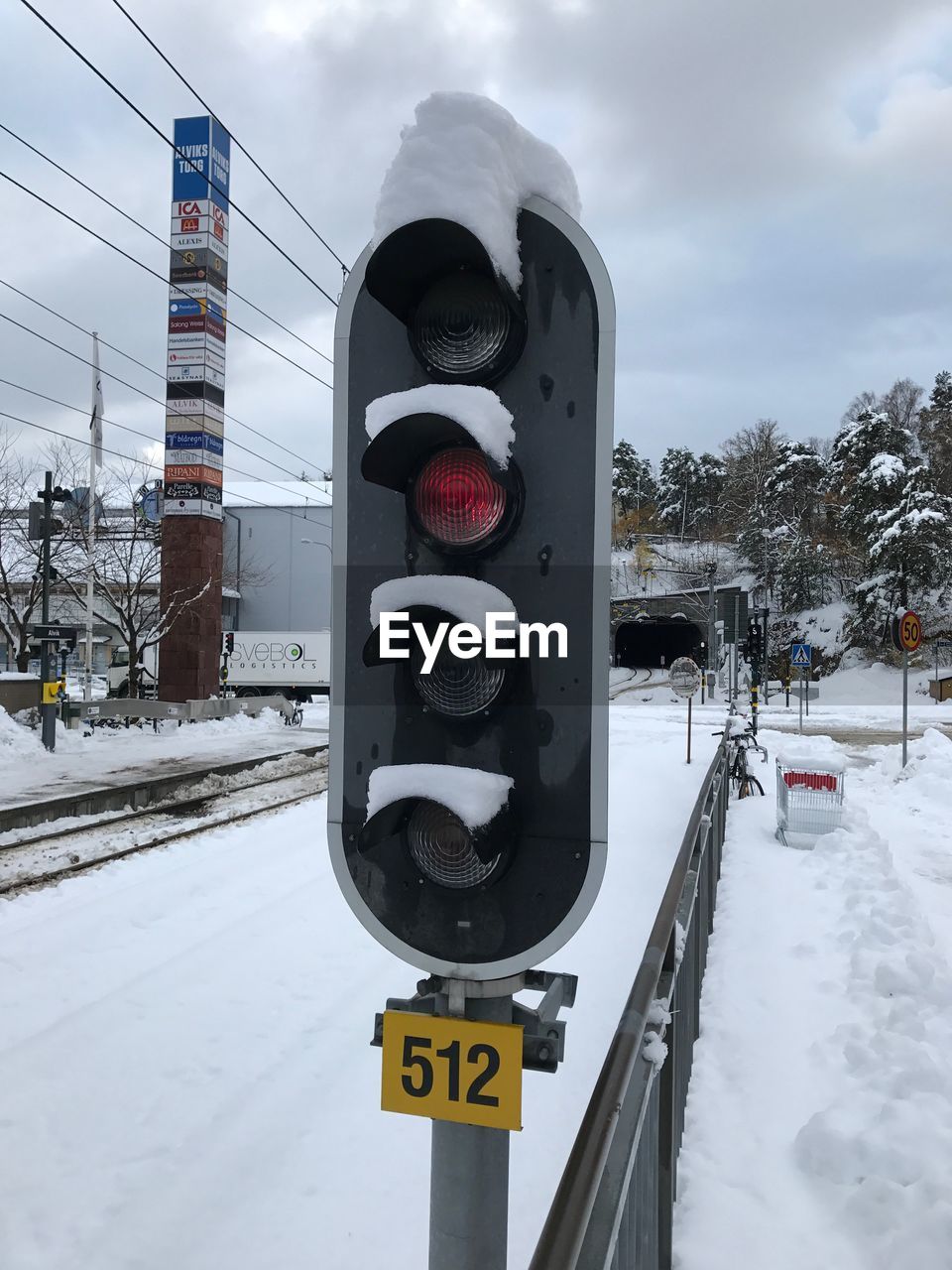 CLOSE-UP OF ROAD SIGN ON SNOW COVERED CITY STREET