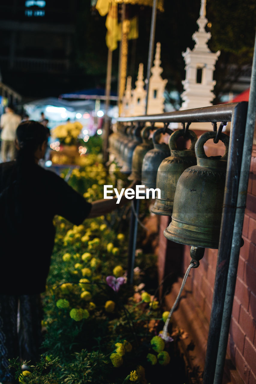 Rear view of people next bells in thailand